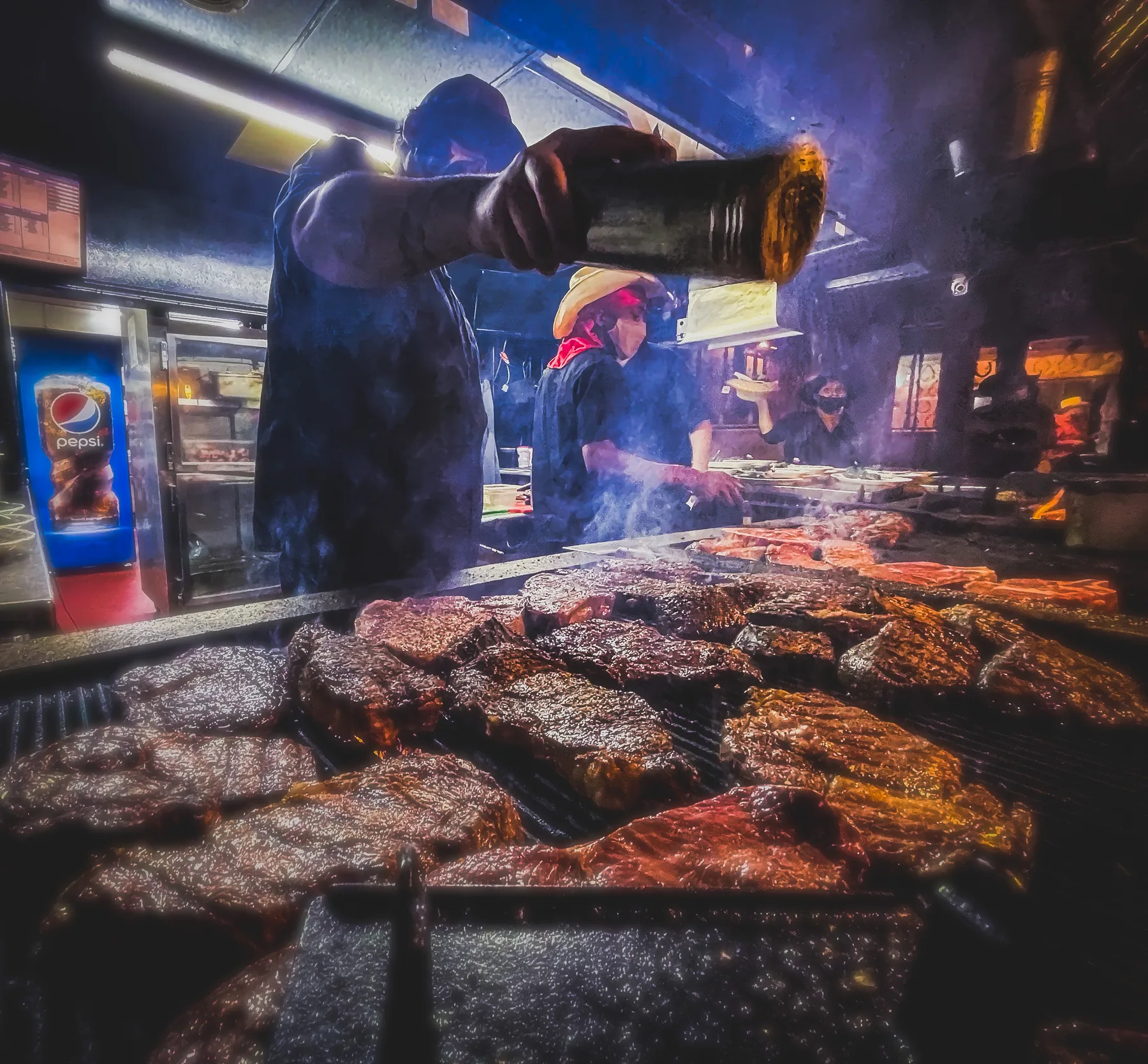 Big Texan chef grilling steaks over open flames